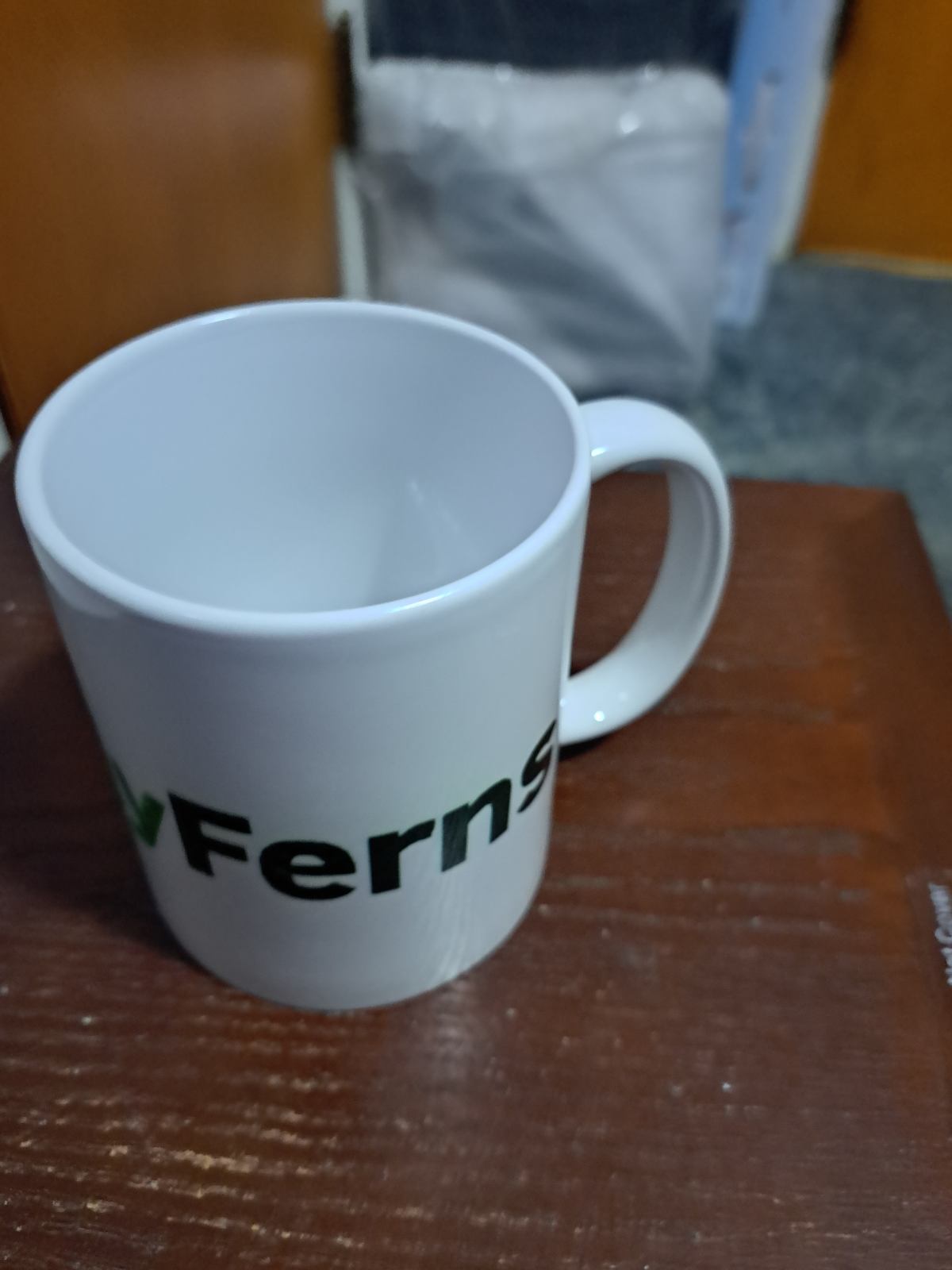White ceramic coffee mug with partial black and green text design from Fantasy Tees Plus featuring Only Ferns parody coffee mug